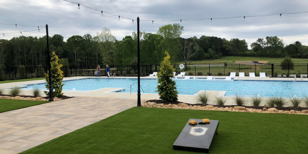 Image of pool and SR-branded cornhole board at Soft Amenity Opening at Montebello in Cumming